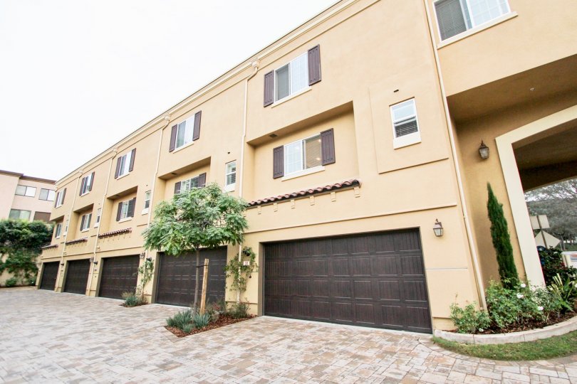 Dark brown garage doors on pink residences inside Ziani in La Jolla CA