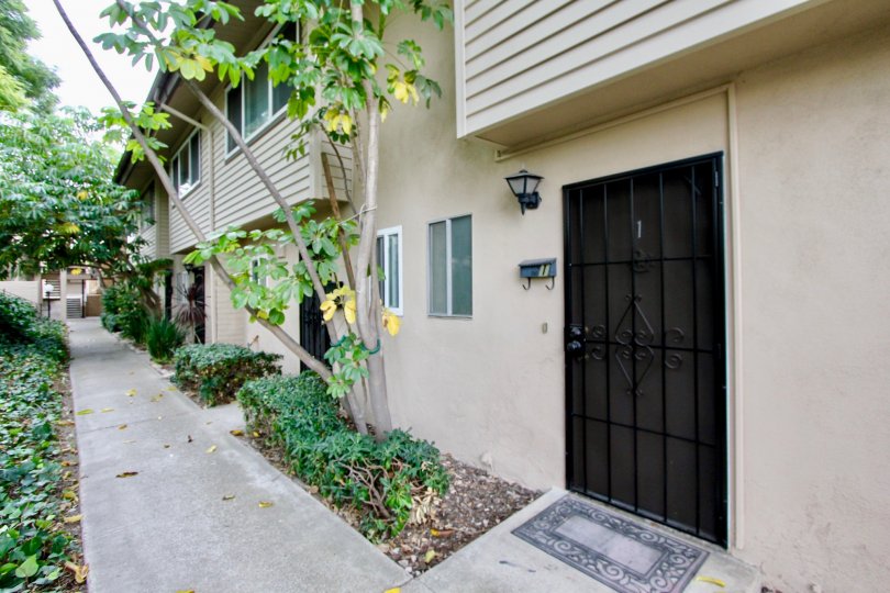 THE IMAGE SHOWS THAT HOUSE IN THE GROSSMONT VILLAGE WHICH HAS BEEN PATHWAY, PLANTS, TREES