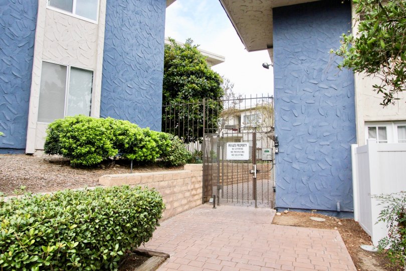 A black iron security gate next to a blue wall at Villa De Sur in La Mesa CA