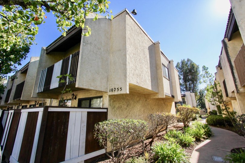 The side of several apartment buildings with a small garden and path running through in the Gold Creek area of Mira Mesa, California