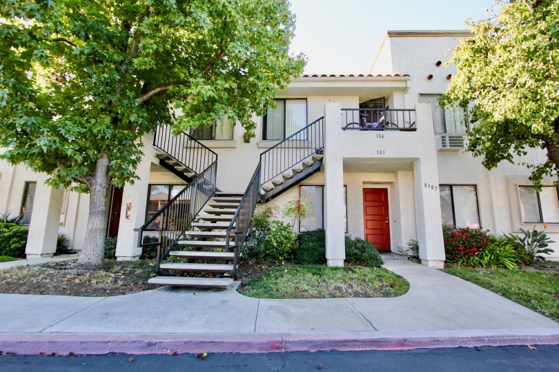 Sunny day trees with front staircase of a residence house in Villas at Capricorn, Mira Mesa, CA