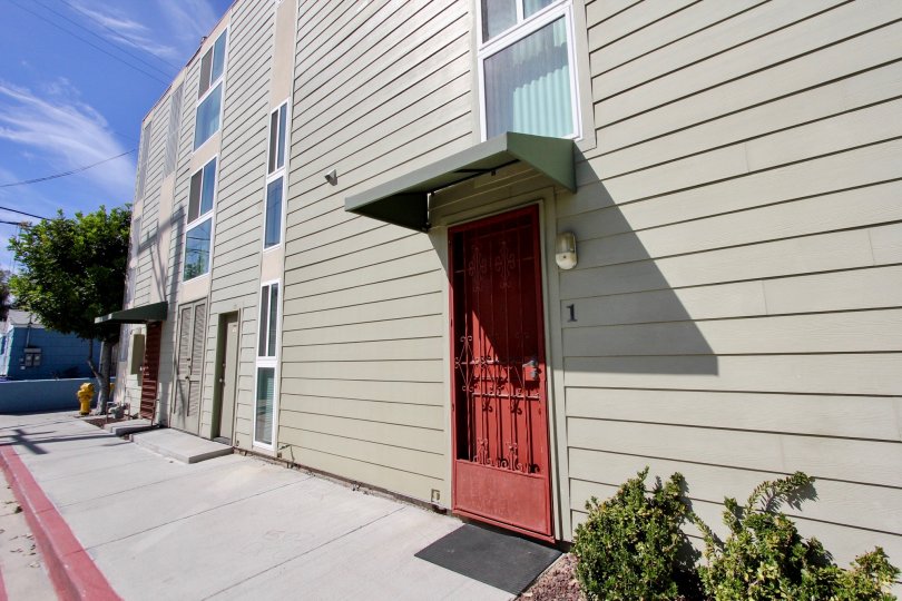 Bright red security door on a gray building at Franklin Shores in Mission Beach CA