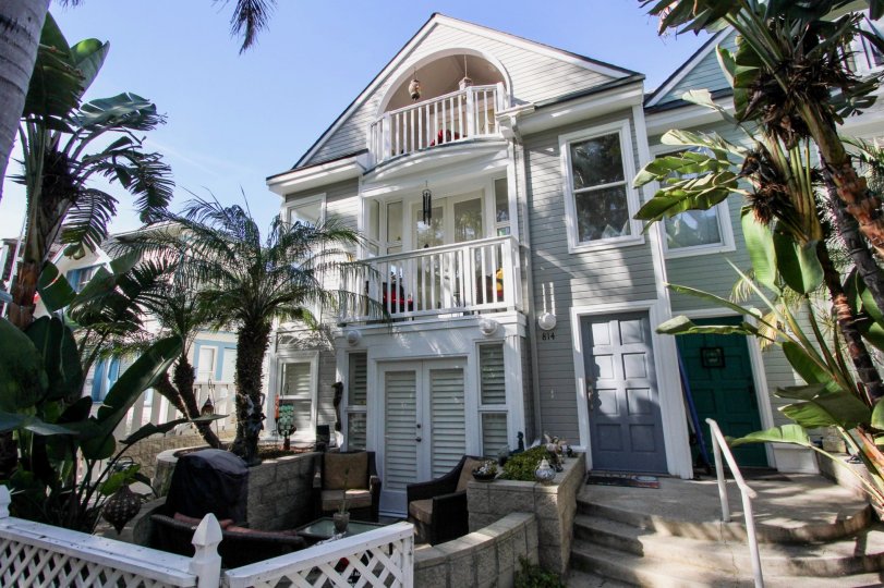 A sunny day outside a home with palm trees and lovely stone work.