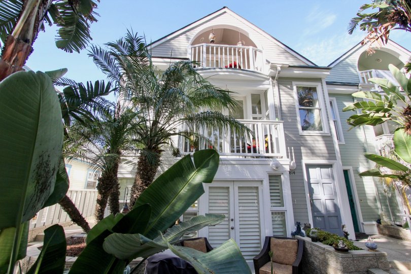 A white house with balconies and some plants before it in Mission Beach city