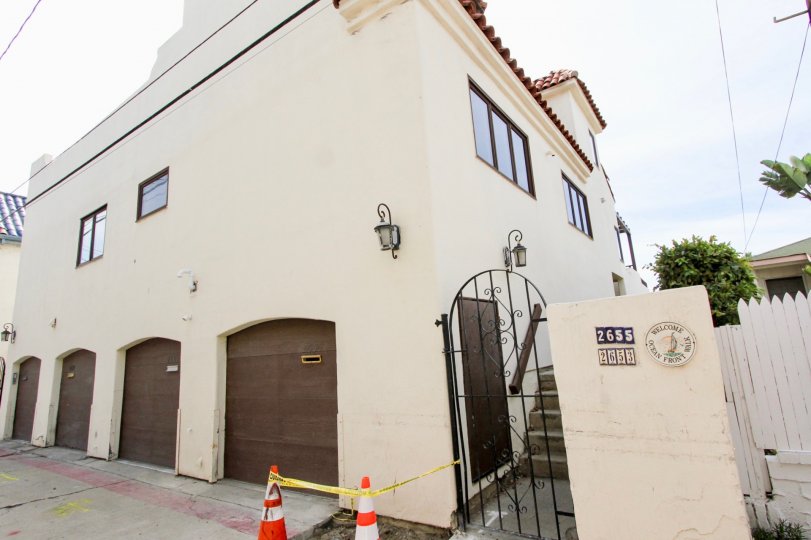 White building with brown garage doors and a black security gate at Ocean Blue in Mission Beach CA