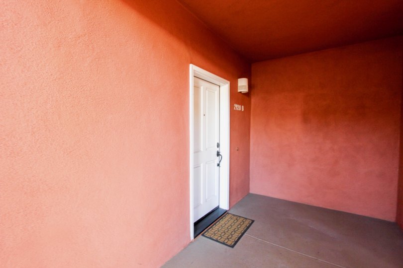 A door is covered the wall painted by red color and numbered the house as 2120