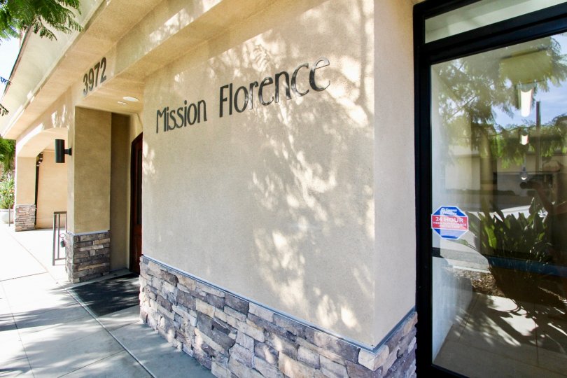 "Mission Florence" is written on a beige wall near the front entrance on a building.