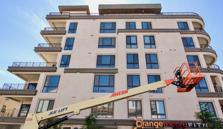 A consturction crane sits in front of an Orange Theory on the bottom floor of Vue on 5th