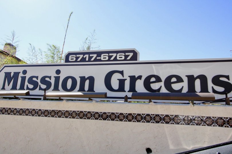 A sunny day in the area of Mission Greens, main sign, trees