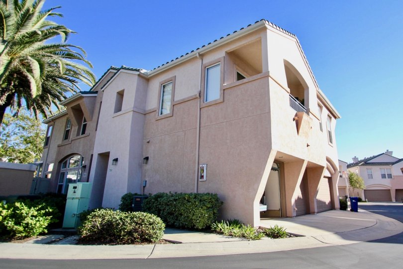 Sunny outdoor view of palm tree and two storey home in Union Square community in Mission Valley, CA
