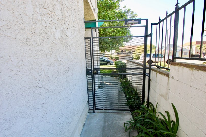 A sunny day in Hamilton Street Condos with a closed gate in an alley way.