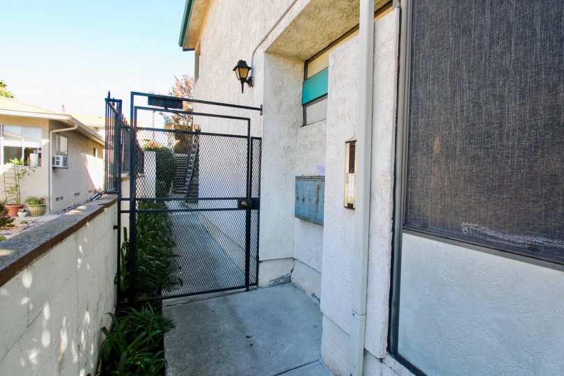 A sunny day in the area of Hamilton Street Condos, gate, fence, mailboxes, sidewalk, air conditioner, condo