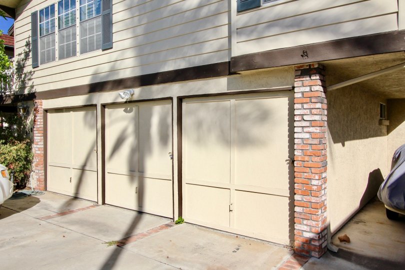 Single car garage units with decorative doors below windows with stylish shutters at Hermitage II