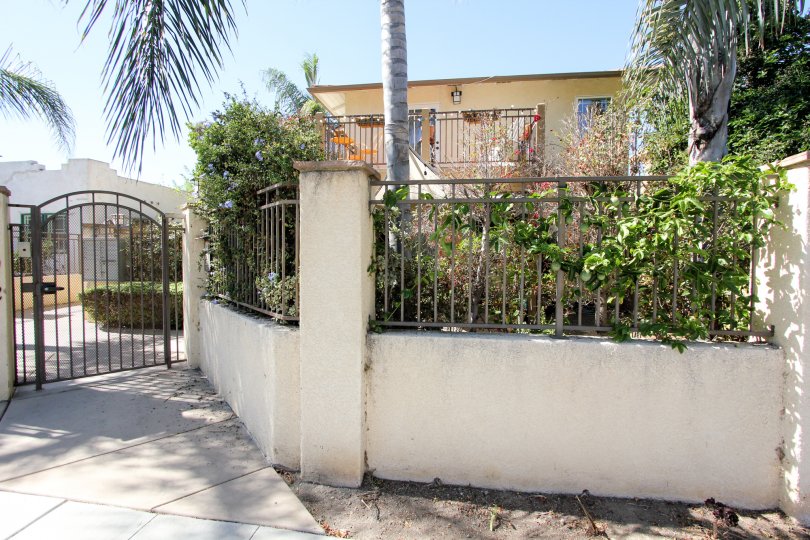 A sunny day in the area of Normal Heights Village. gated entrance, palm trees, balcony, condo. brick wall