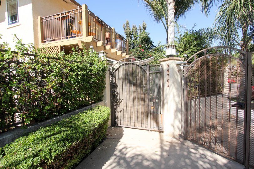 a house in Normal Heights Village in california with some trees inside with a gate