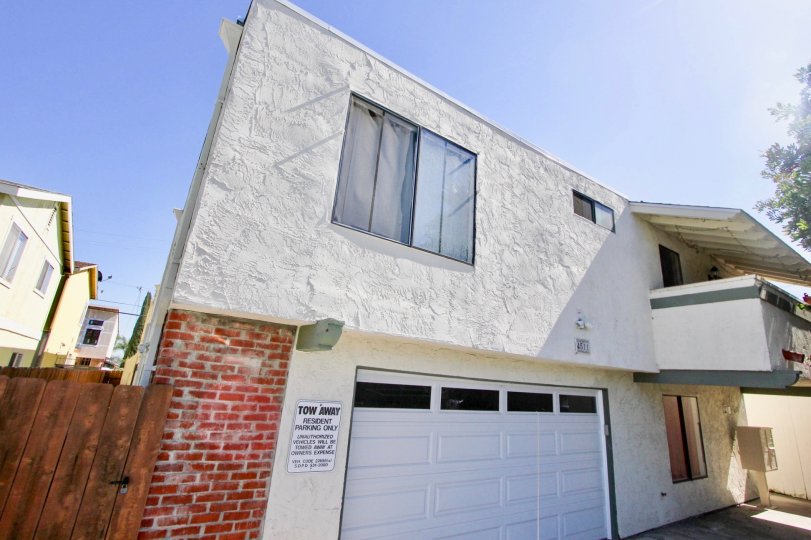 A Sunny day with a white house and garage in Oaktree Villas