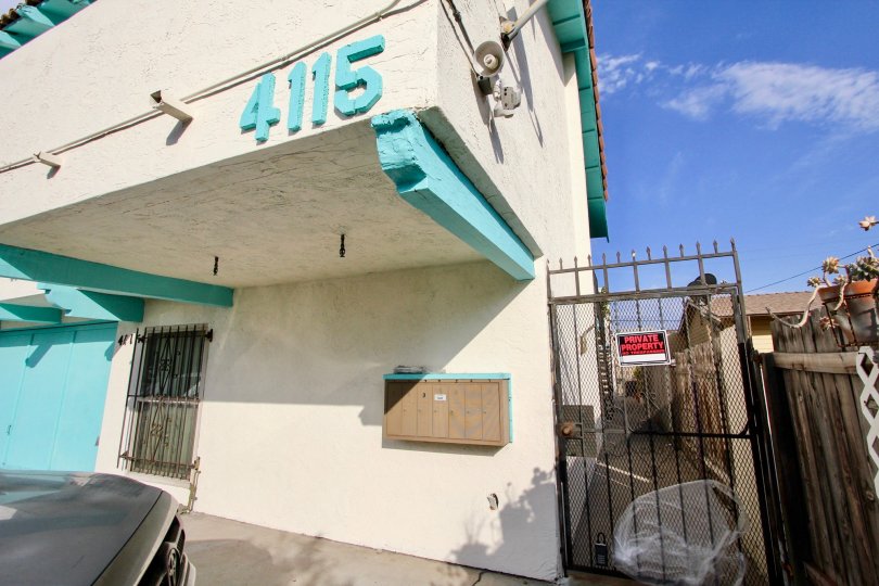 A sunny day in the area of 4115 Cherokee Avenue, gated entrance. barred windows, car, sign