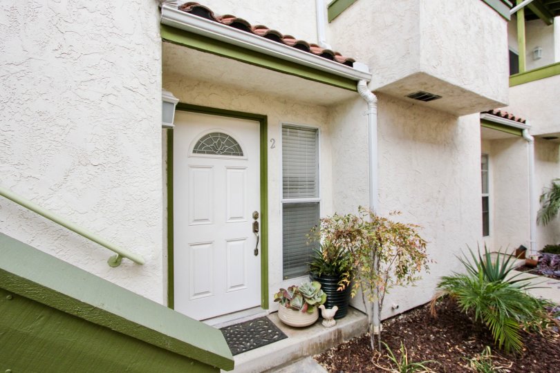 View of a main door of a house with green frame and with white door in the Grim Townhomes