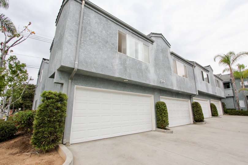 A sunny day in the area of Phoenix II, condos, garage, bushes, windows