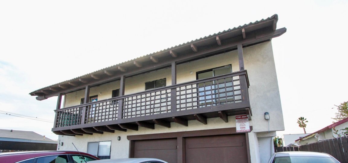 Front of house with long balcony in top floor and two garage doors in bottom level in the Triton Condos