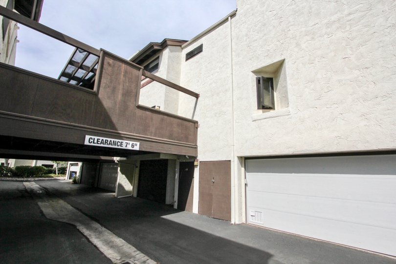 A sign indicates there is a low clearance under a bridge between two buildings at Sea Colony condos