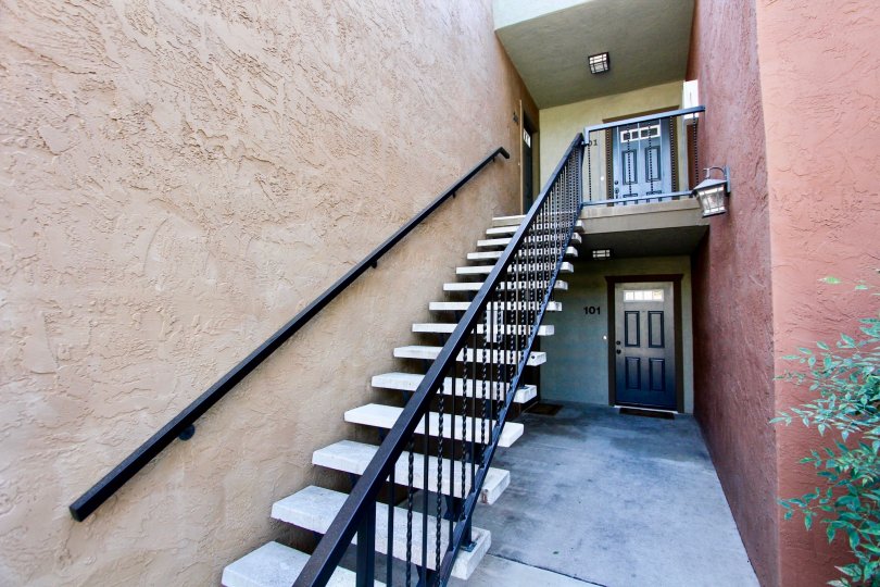 Two story red housing units with black doors at the La Estancia in Oceanside CA