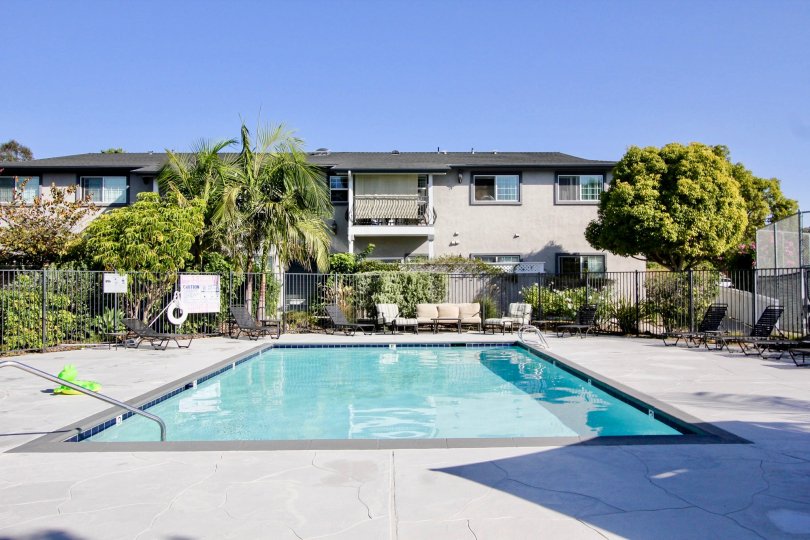 pool inside housing area with greenery and kid toys around