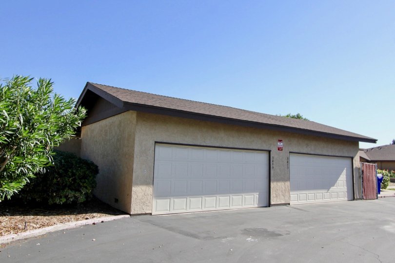 Two large garage doors with squares near a driveway at Los Arbolitos in Oceanside CA