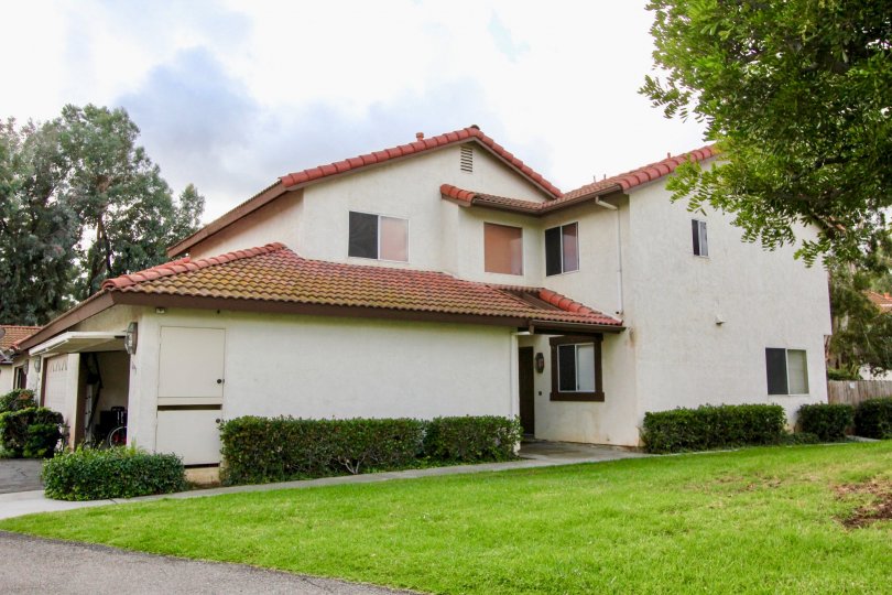 A sunny day in the area of Mission Meadows, outside, grass, yard, bushes. garage. bike