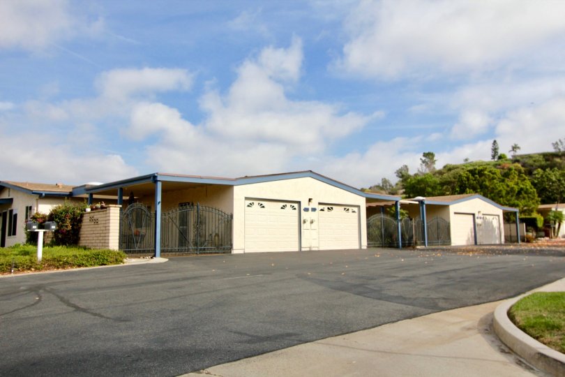 An exterior view of the Oceana Mission homes with garage and private gated carports from the street.