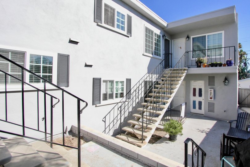 The sophisticated front side of a house with stairs and few windows in 839 Sapphire community is displayed.