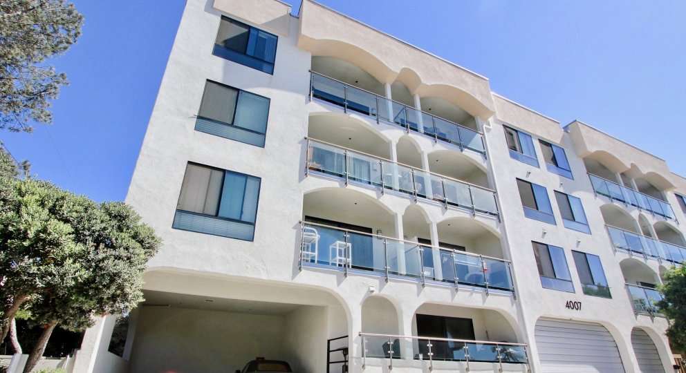 A sunny day in the area of Castaway, high rise condos, outside, trees, table, balcony