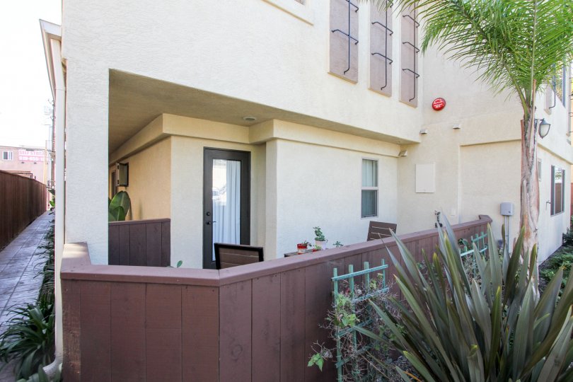 Sit out of big building in the Felspar Townhomes with some plants and chairs.