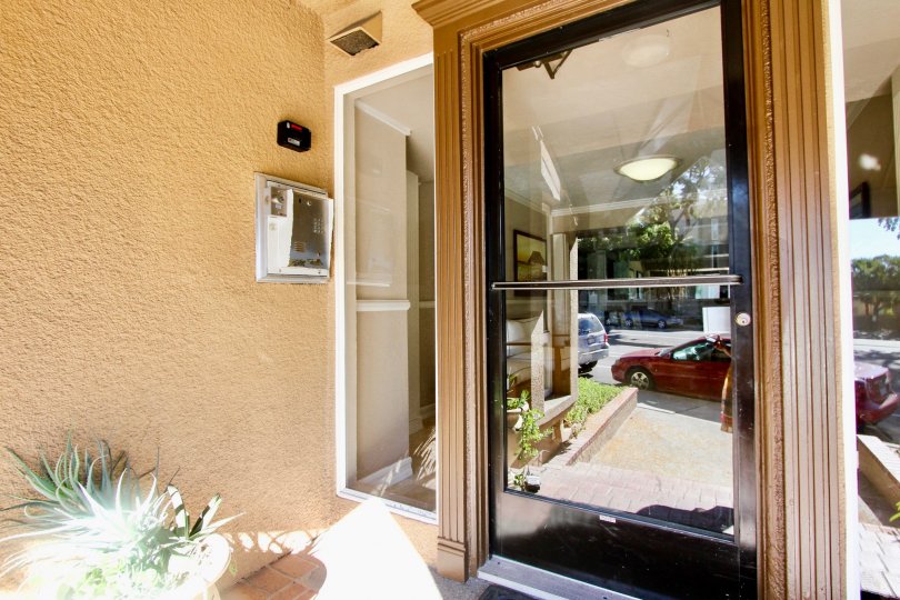Through the Glass door Can see Car is parking and has flower pot with security box