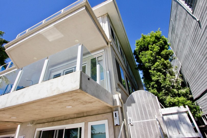THE BUILDING IN THE SAIL BAY CONDOS WITH THE BALCONI, TREES, GATE
