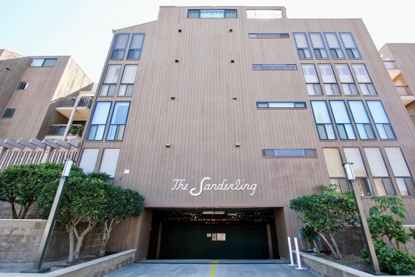 A tall building on a sunny day with garage parking at the Sanderling Community