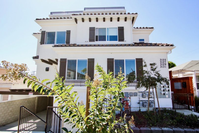 A crisp white Californian house with traditional shutters on a sunny day