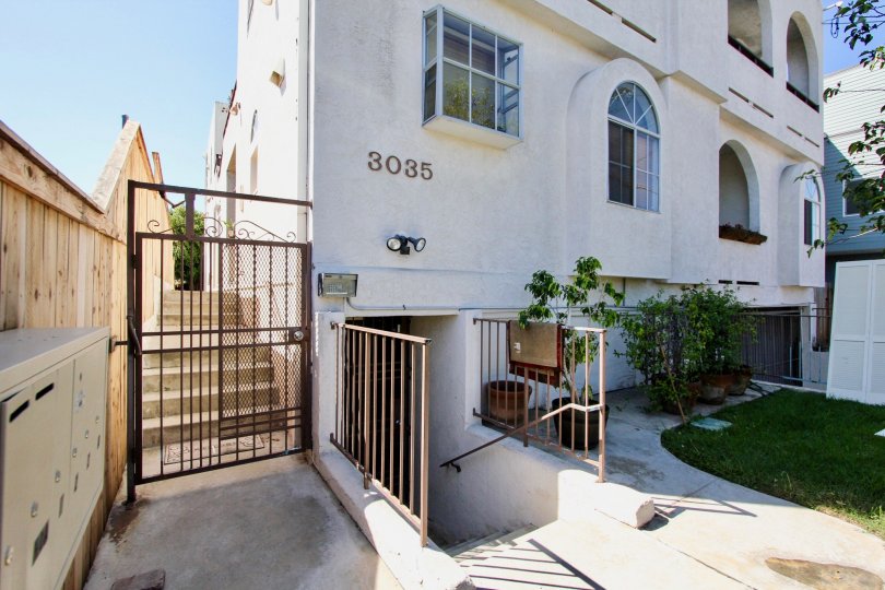 A wooden privacy fence shifts up as the sidewalk ascends with stairs at Primrose Villas