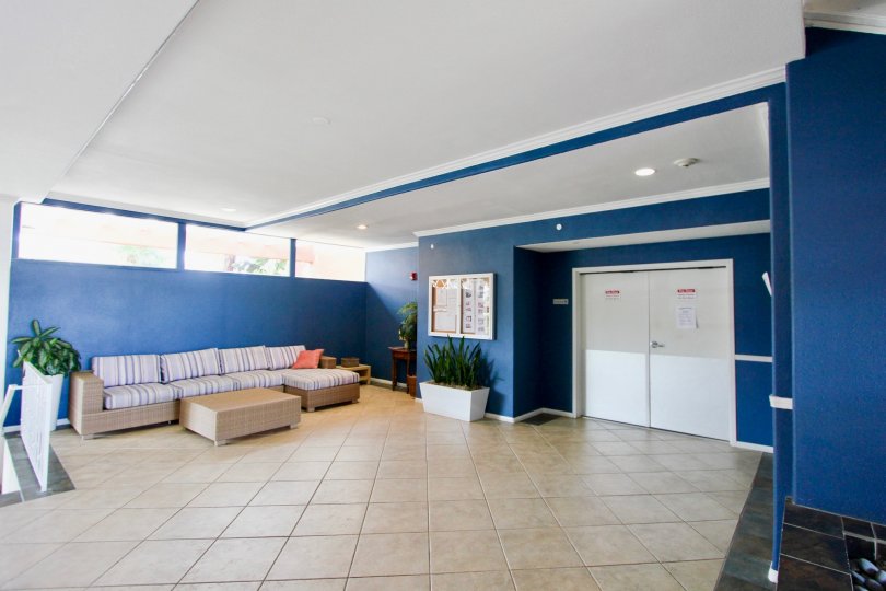 Blue interior of modern lobby with couch and white double doors in Yacht Club Condos