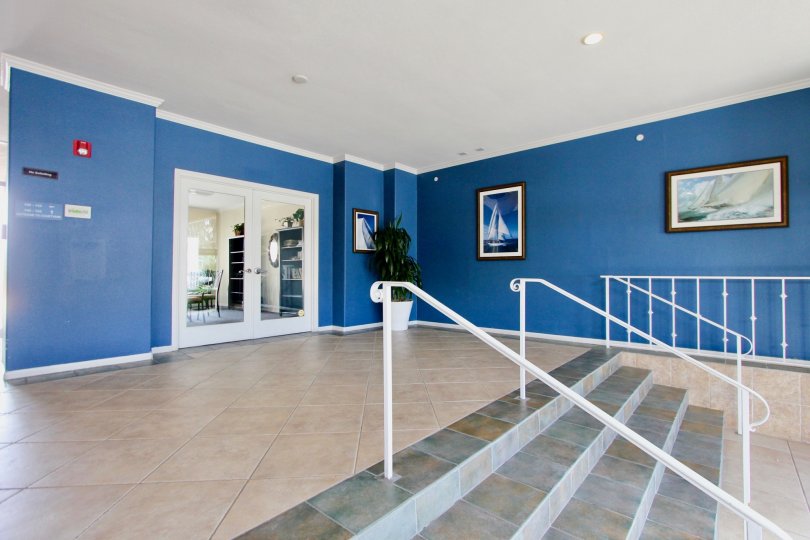 Nautical themed entrance foyer with framed art and tile floors at Yacht Club Condos