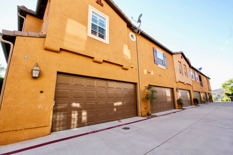 Brown buildings with garages and drive way in Gianni