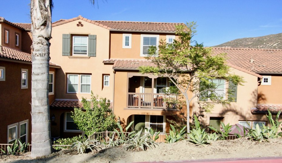 A three story house with porch in Gianni with landscaping