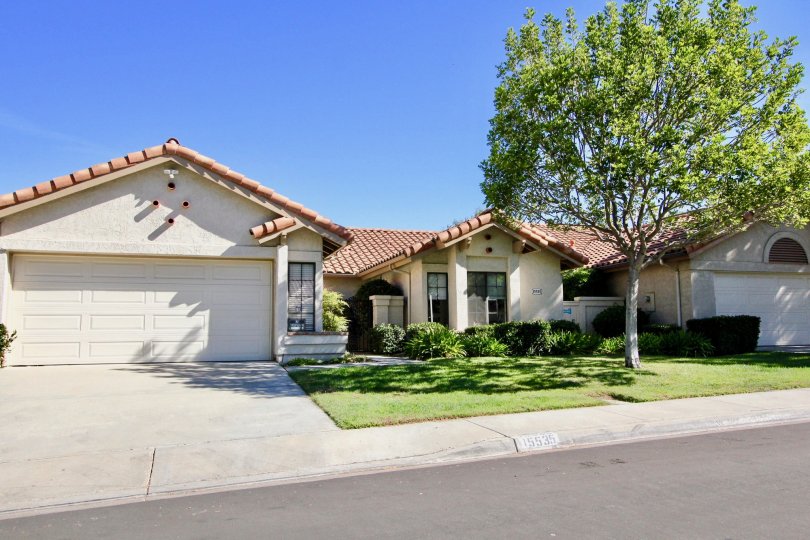 A white property with a garage and landscaping in Las Flores