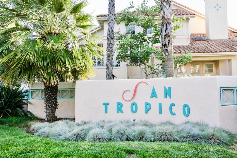 Blue and red sign on a pink wall at San Tropico in Rancho Bernardo CA