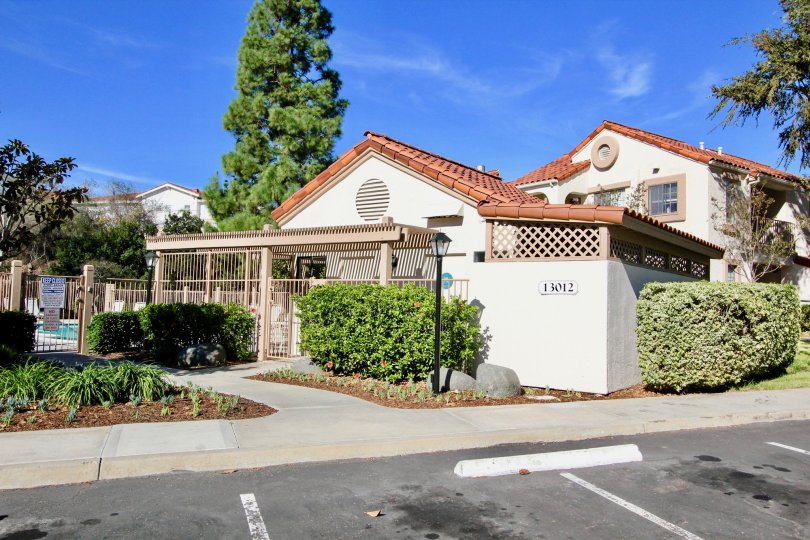A villa in Stony Brook has a number 13012 with tall trees and plants