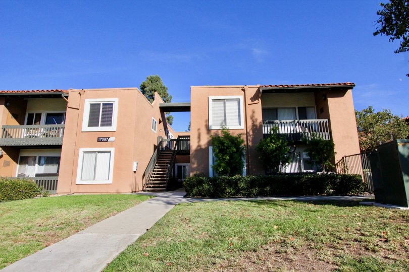 Two story pink buildings with lush green grass at Water Bridge in Rancho Bernardo CA