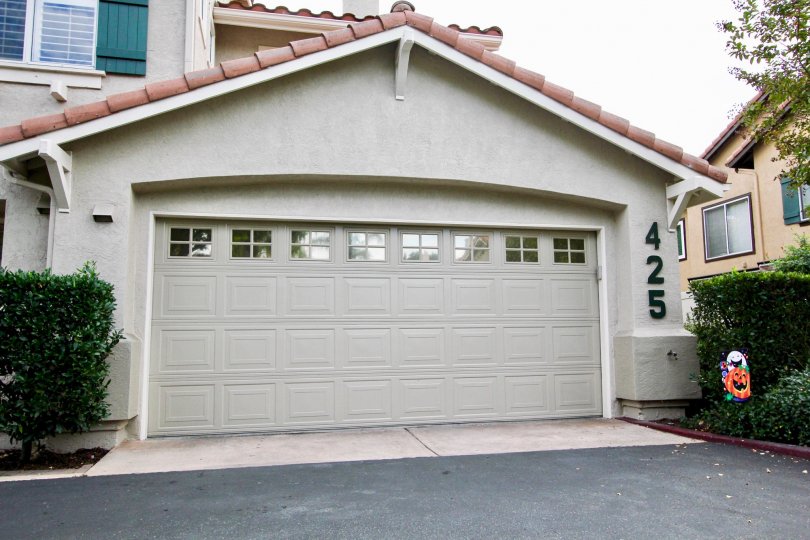 A sunny day in the area of California Mariposa, garage, bushes, window, condo