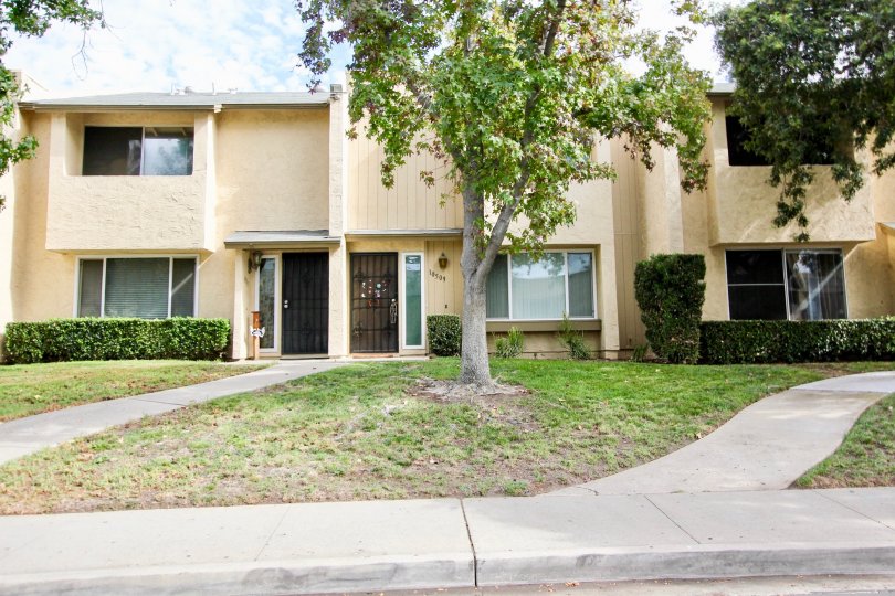 The front of three gorgeous white-stucco townhomes in the Corsican Villas development.