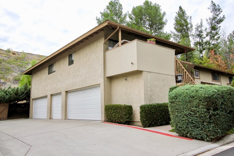 The exterior of Fletcher Valley Villas with three garage doors a balcony and paved driveway