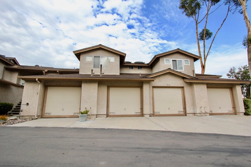 Tan two story house with four garages and cement driveway, house number 7458 in Highland Trails, Santee, CA